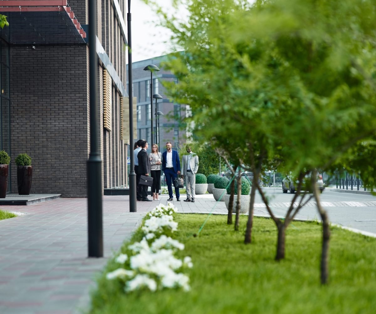 Young employees communicating outdoors by modern office building