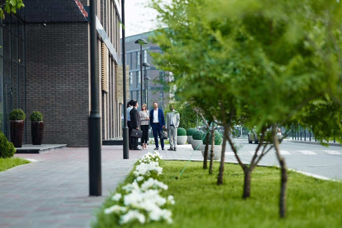 Young employees communicating outdoors by modern office building
